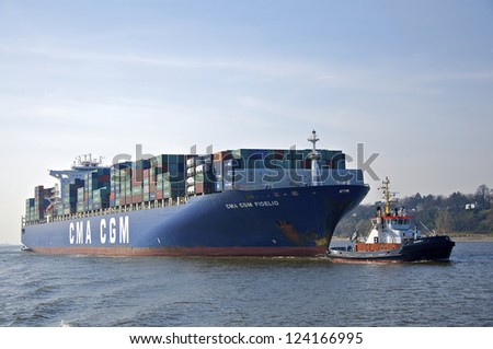 HAMBURG - APRIL 07. A container ship is pulled by a tug into the harbor. Hamburg on April 07, 2010. Movement of goods and container shipment is a significant economic factor for German trade