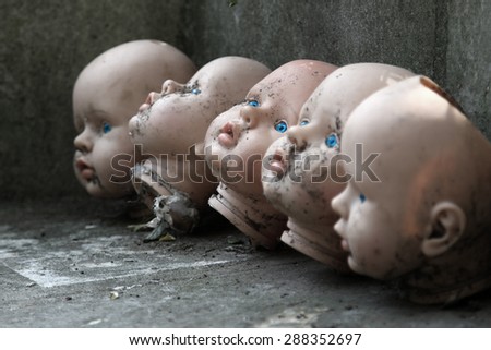 several children head doll with blue eyes lie in the old yard - scary stories - fear - a fairy tale