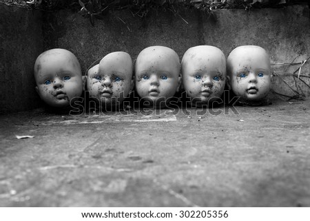 several children head doll with blue eyes lie in the old yard - scary stories - fear - a fairy tale