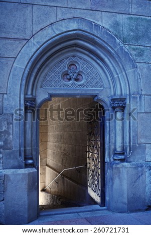 open wide the door to the entrance to the Gothic castle with knights otributami on the stone walls - helmet, sword, sword, shield and wide helical staircase in an old castle Boynetse in Slovakia