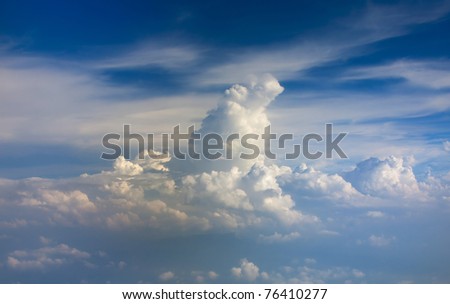 Beautiful view on big white vertical cloud like moutain under horizontal clouds on blue sky background