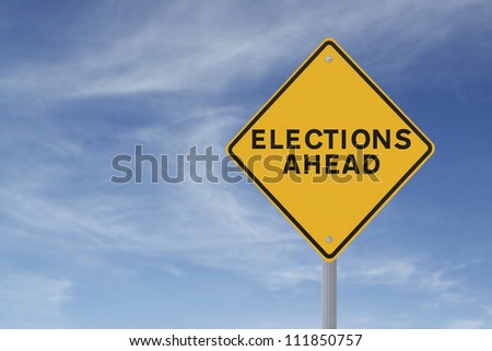 Road sign announcing elections ahead (against a blue sky background)