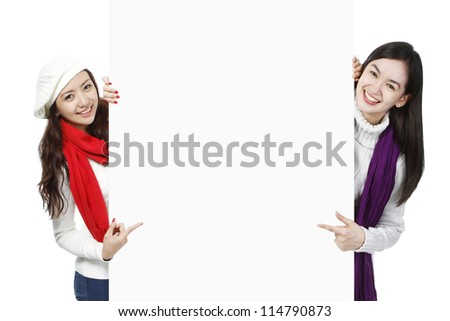 Blank space between two young women wearing winter or holiday attire