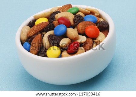 Trail mix in a white bowl on blue background
