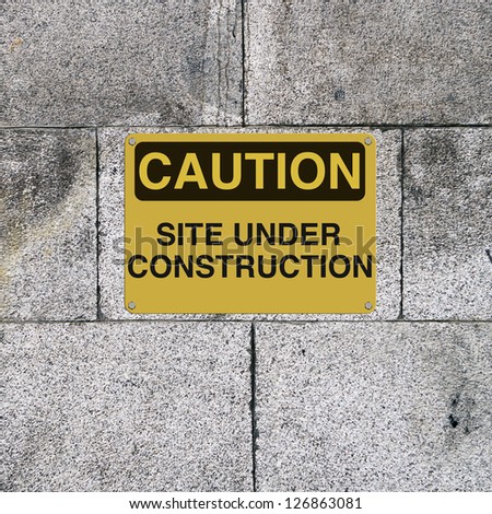 A safety sign mounted on a brick wall. Applicable to workplace safety or website downtime status.