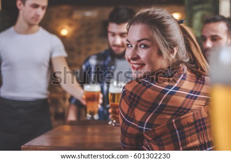 Waiter Serving Beer at a Pub. Group Of Hipster Friends Drinking Beer