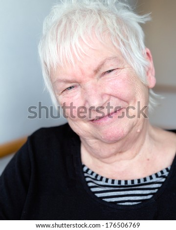 Portrait of happy older senior female with short white hair