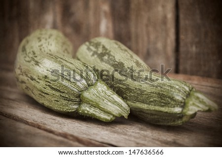 Zucchini on wooden table. Photo in old style