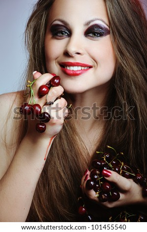 Young beautiful happy smiling woman with cherries in hands
