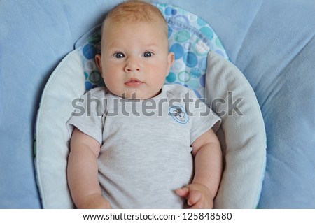 Adorable three month baby lying in a blue blanket