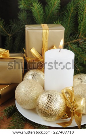 Christmas Card with decorations on texture wooden background. White candle, gift boxes with presents,  xmas tree and color balls.