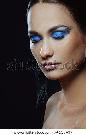 beautiful girl with blue make-up in long earrings