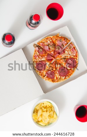 Pizza dinner. View from above of box with pizza, cola plastic cups