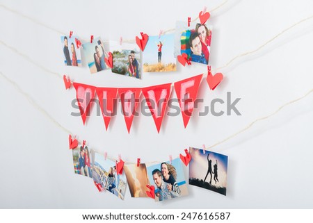 Homemade love decoration. Wall with pictures and garland hanging on clothesline
