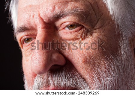 Senior man./ Closeup of eyes of a senior man over a black background