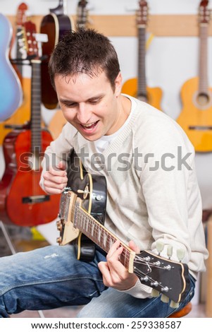 Man playing electric guitar on music shop