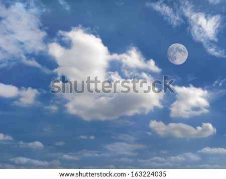 dramatic clouds moving across summer blue sky with moon