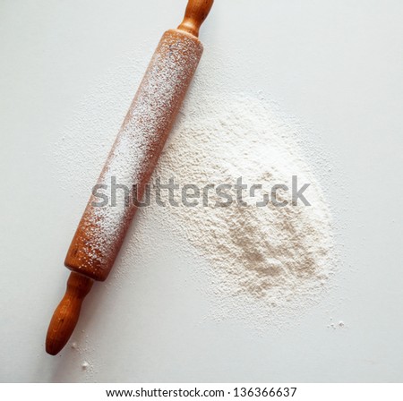 Wooden Rolling Pin With White Wheat Flour On The Table. Top View