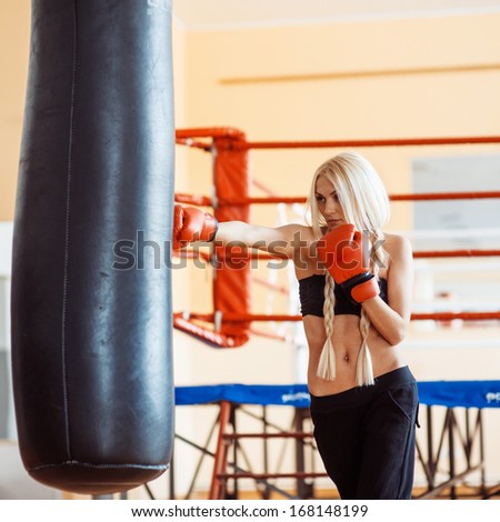 Young woman fitness boxing in front of punching bag