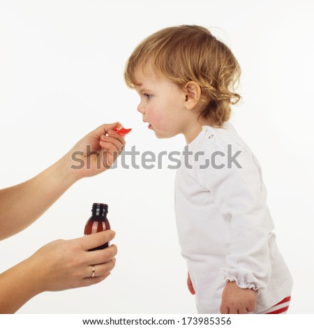 Doctor hand giving spoon dose of medicine liquid drinking syrup to child