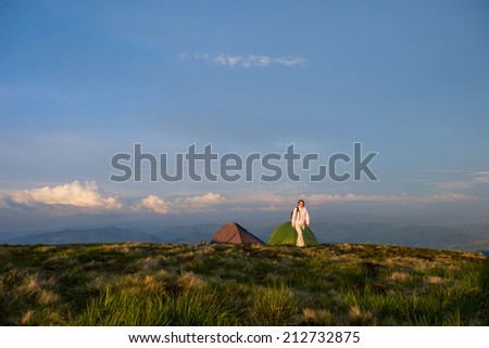 Woman wild camping on grassy mountain top