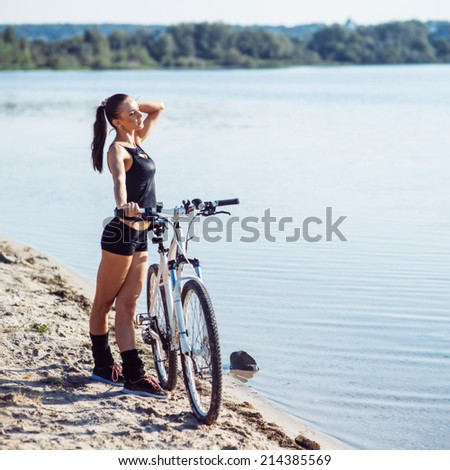 woman on a bicycle in a park area near the water