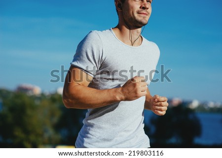 Attractive strong athlete running along the sea