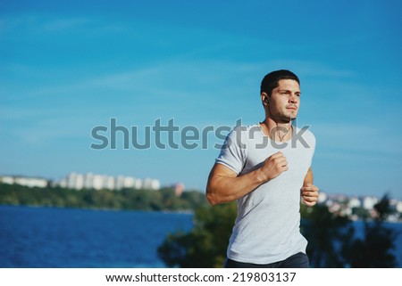 Attractive strong athlete running along the sea