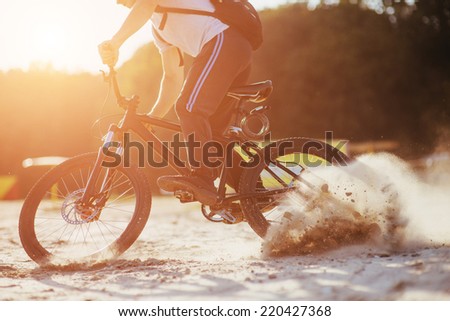 low angle view of cyclist riding mountain bike on rocky trail