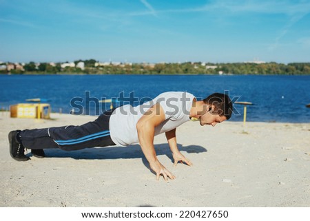 Strong attractive runner is pushed from the floor before morning jog