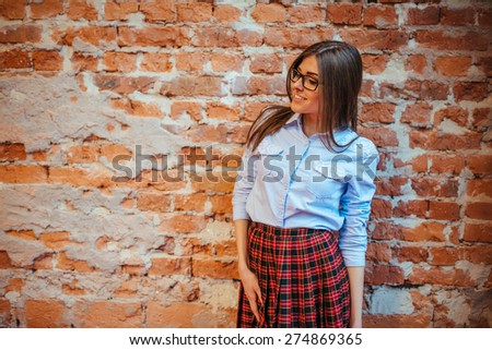 Beautiful young woman stands near the old brick wall. Youth style.Art processing and retouching photos special.
