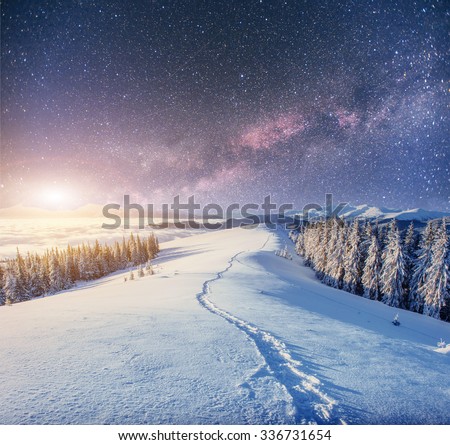 starry sky in winter snowy night. fantastic milky way in the New Year\'s Eve. Starry sky snowy winter night. The Milky Way is a fantastic New Year\'s Eve. Winter road in the mountains