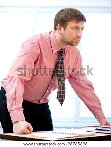 Angry businessman leans on the table