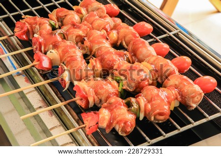 Barbecue  bacon wrapped sausages grilling on a  Infrared  gas grills.