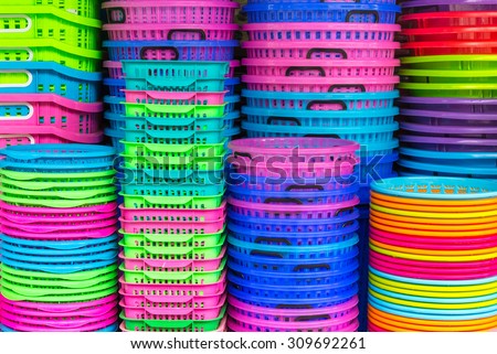 A stack of colorful recycled plastic buckets on display at a sundry store.