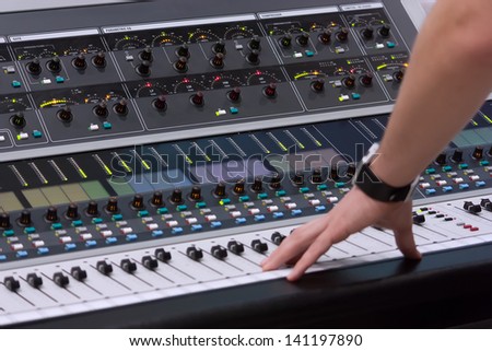 sound engineer\'s hand moving on sound mixing board