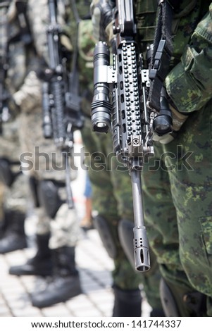 Soldiers lined up in camouflage/Soldiers in army uniform line up holding guns