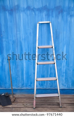 Blue iron wall before the aluminum ladder