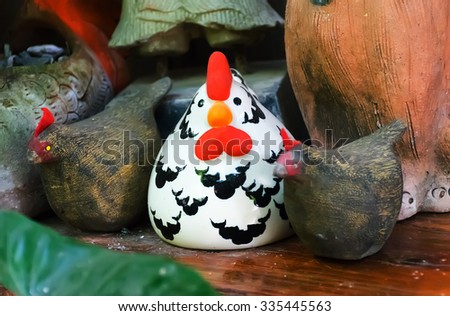 ceramic,old Ceramic on the  wood floor, Ceramic Chicken,Decorative ceramic,\
Chicken with colorful ceramic shape,beautiful ceramic of thailand,doll on the floor.