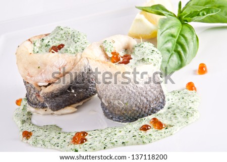 Sea bass fillet in spinach sauce with red caviar