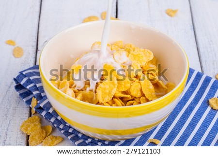 Breakfast table with cornflakes cereal and milk