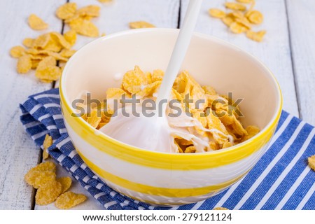 Breakfast table with cornflakes cereal and milk