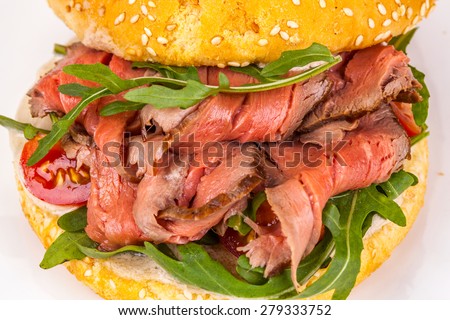 Sandwich with meat, arugula, tomatoes
