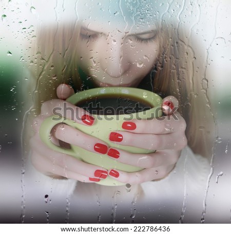 girl with cup of coffee outside the window