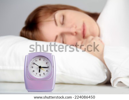 alarm clock and sleeping woman