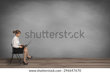 woman sitting on chair and holding laptop