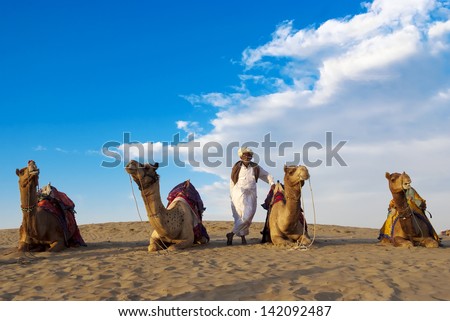 JAISALMER, INDIA - FEB 26:  Cameleer and his herd at the Sam Sand Dune on Feb 26, 2013 in Jaisalmer, India.   Apart from farming, camel riding activity is another income source for desert villagers