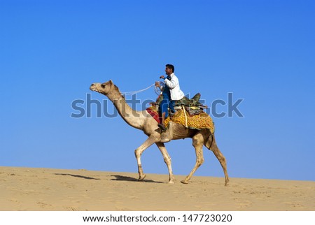 JAISALMER, INDIA - FEB 25:  Cameleer at the Sam Sand Dune on Feb 25, 2013 in Jaisalmer, India.  Apart from farming, camel riding activity for tourists is another income source for desert villagers