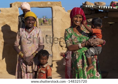 RAJASTHAN, INDIA - FEB 27: Rajasthani family in front of their mud hut on February 27, 2013 in Jaisalmer, India. There are many tribes in Rajasthan with the differences in costumes, jewellery etc.