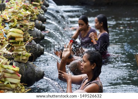 BALI, INDONESIA - MAY 6: Worshippers make an offering at the Tirta Empul Temple on May 6, 2013 in Bali, Indonesia. They believe that water from the spring is holy and has the healing power.